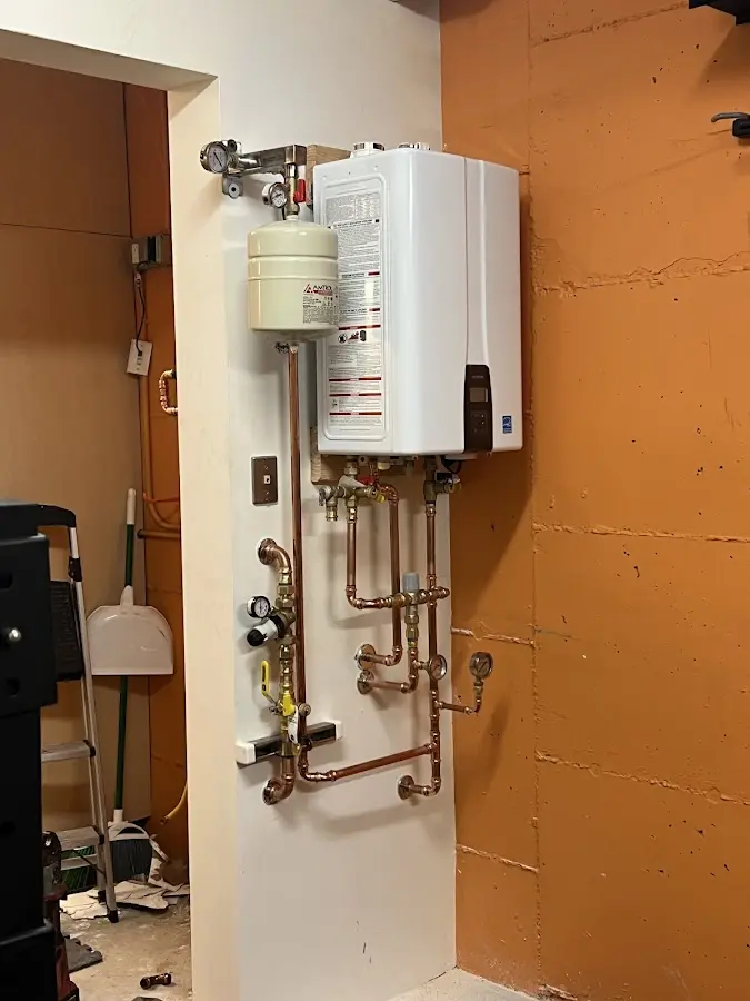 Plumbing technician inspecting water heater connections in Black Diamond